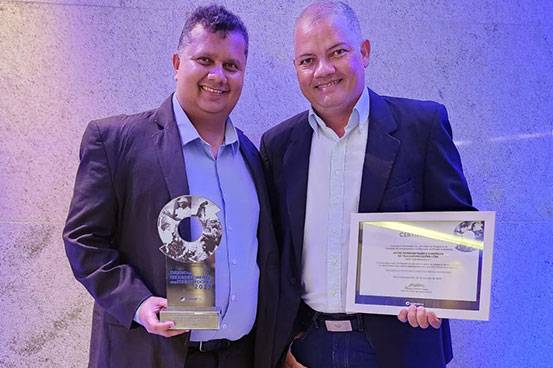 Flávio Silva, Diretor de Tecnologia, e Wellington Novaes, Coordenador da Filial-MG, comemorando a conquista do troféu e certificado.